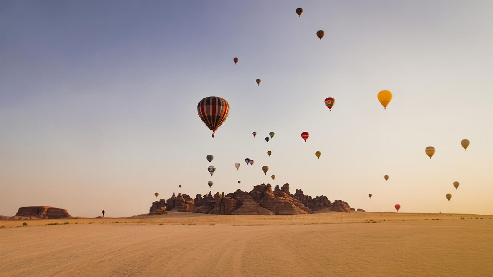 Hot-air balloon over the rock formations of AlUla at sunrise