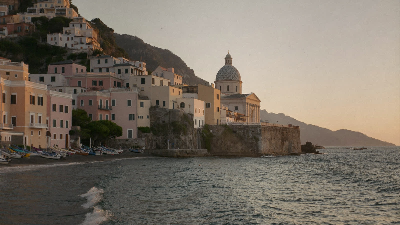 Positano's pastel cliffside houses and the dome of Santa Maria Assunta at golden hour, Amalfi Coast