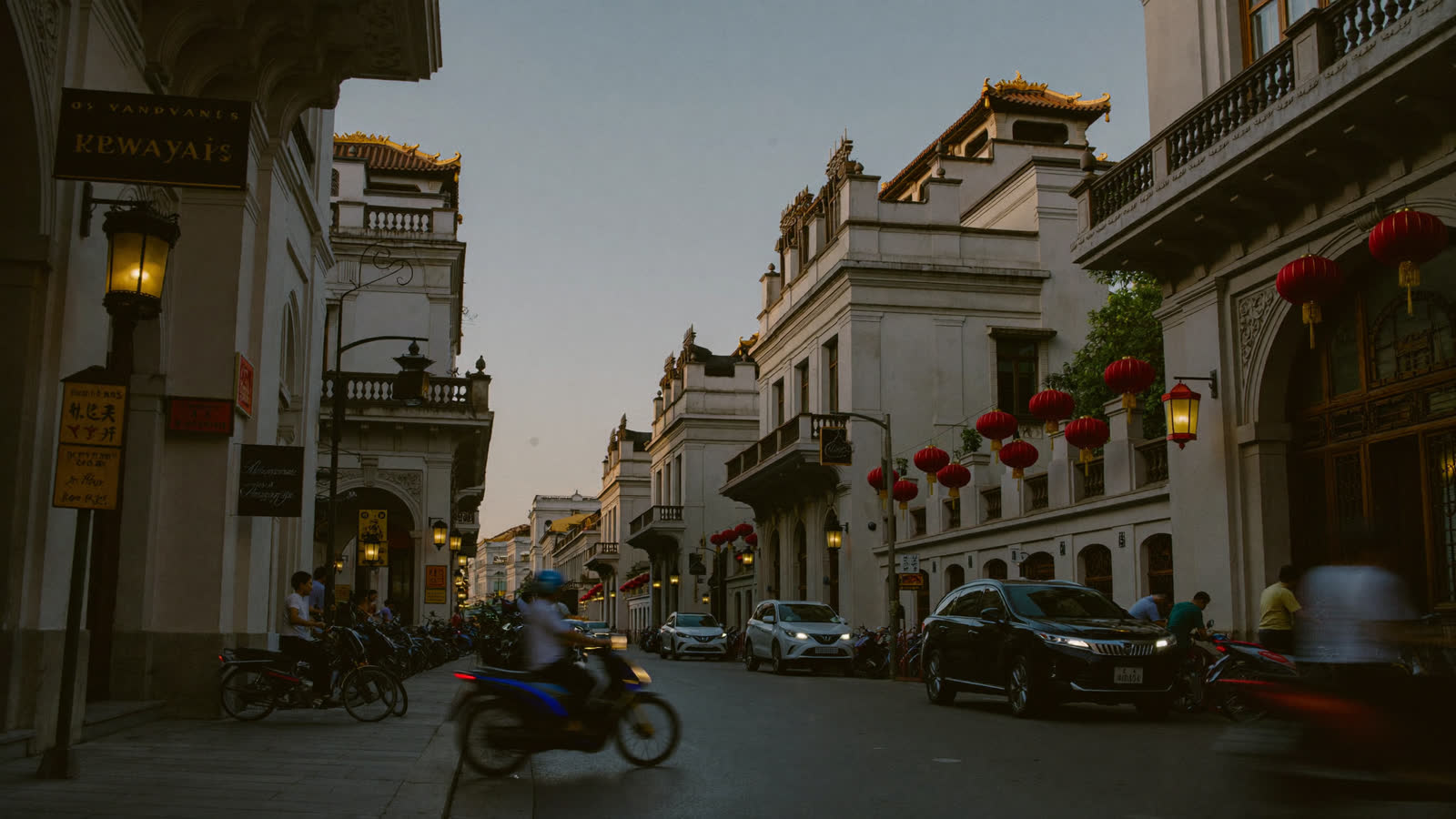 Hanoi Old Quarter street with colonial facades and lanterns at dusk