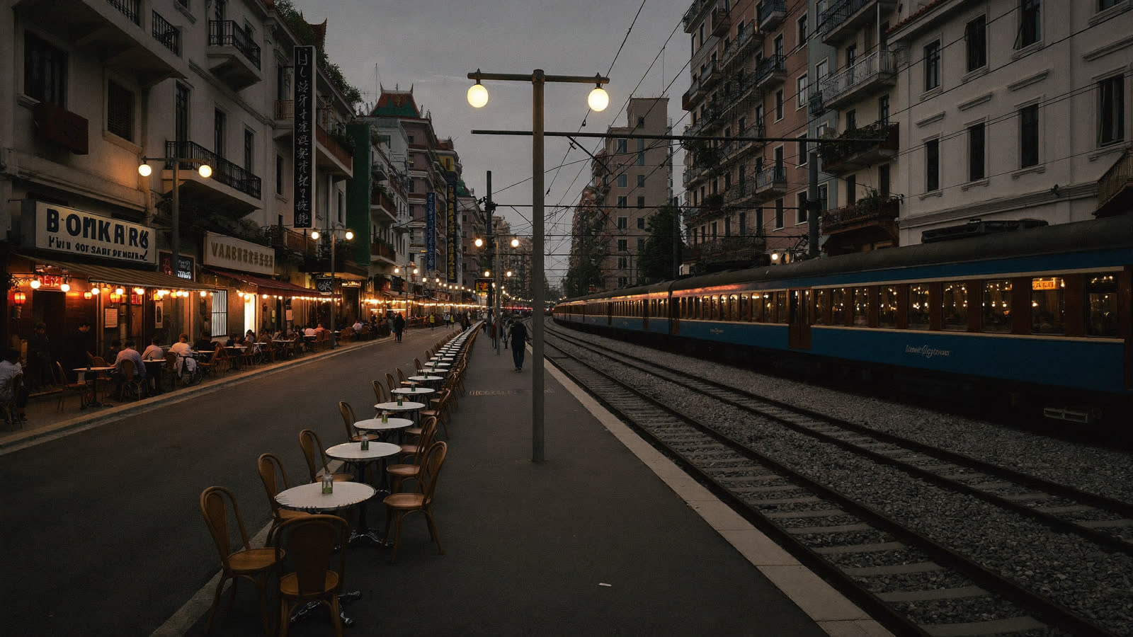 Cafe tables beside the rails on Hanoi's Train Street at evening
