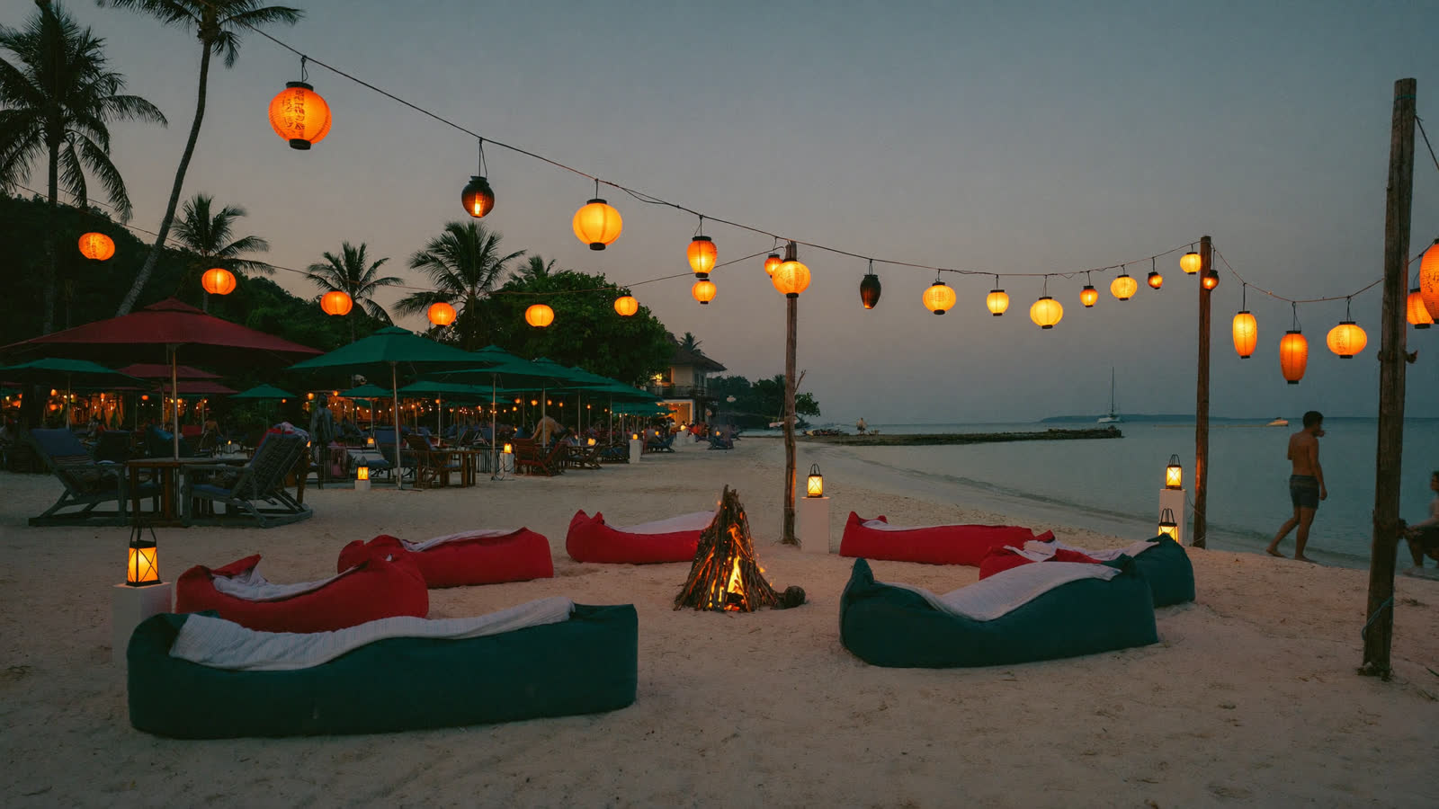 Beach club at dusk with lanterns and bonfire on the sand, Koh Samui