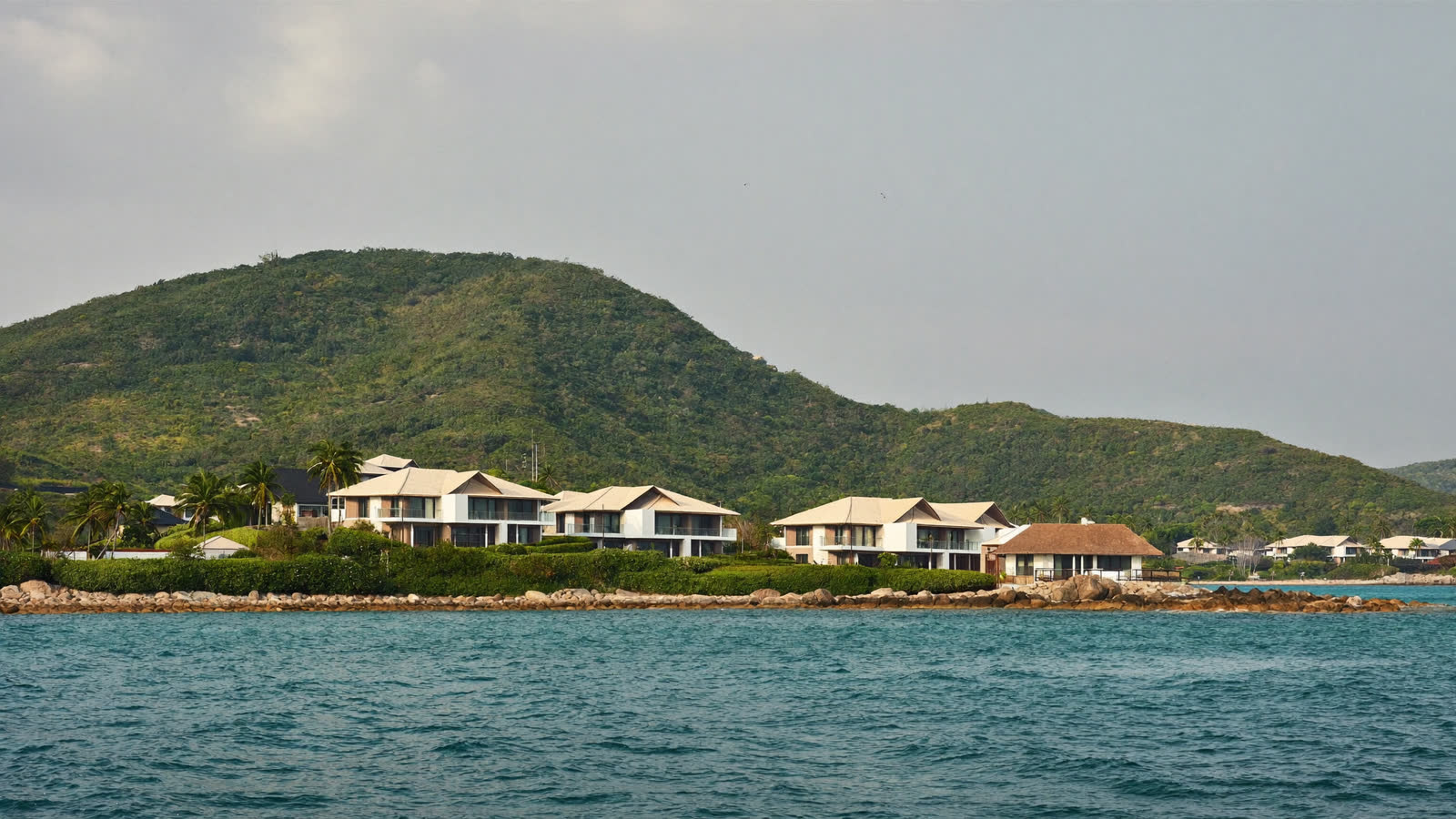 Private island resort villas among rocks and palms, Gulf of Thailand