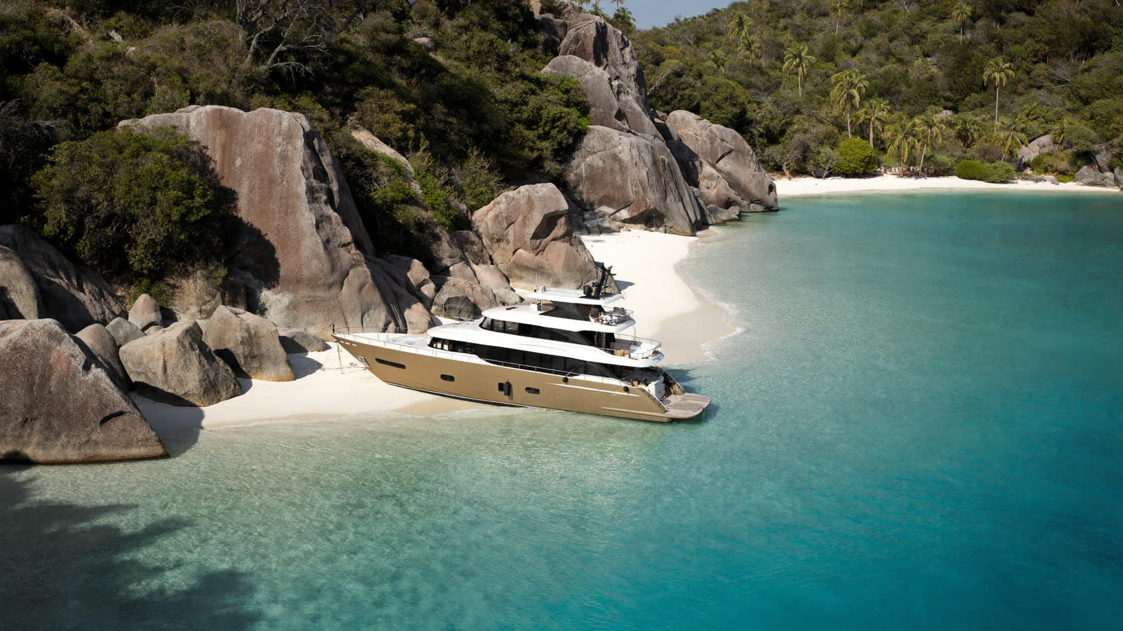 Luxury motor yacht anchored off a granite-boulder beach, Koh Samui