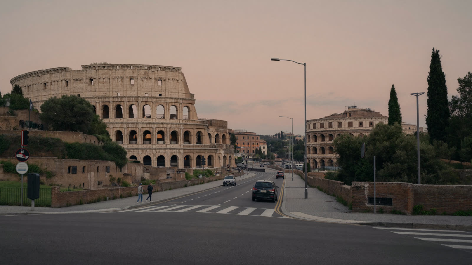 Colosseum at dawn in soft pink light with empty street, Rome
