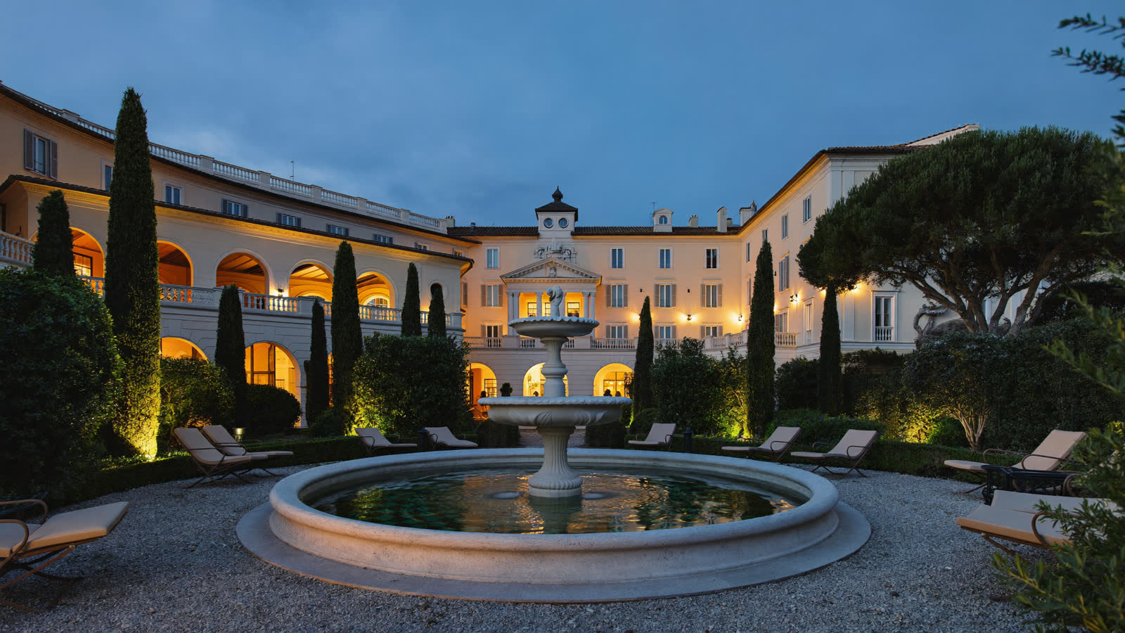 Terraced Italian hotel garden with marble fountain at dusk, Rome