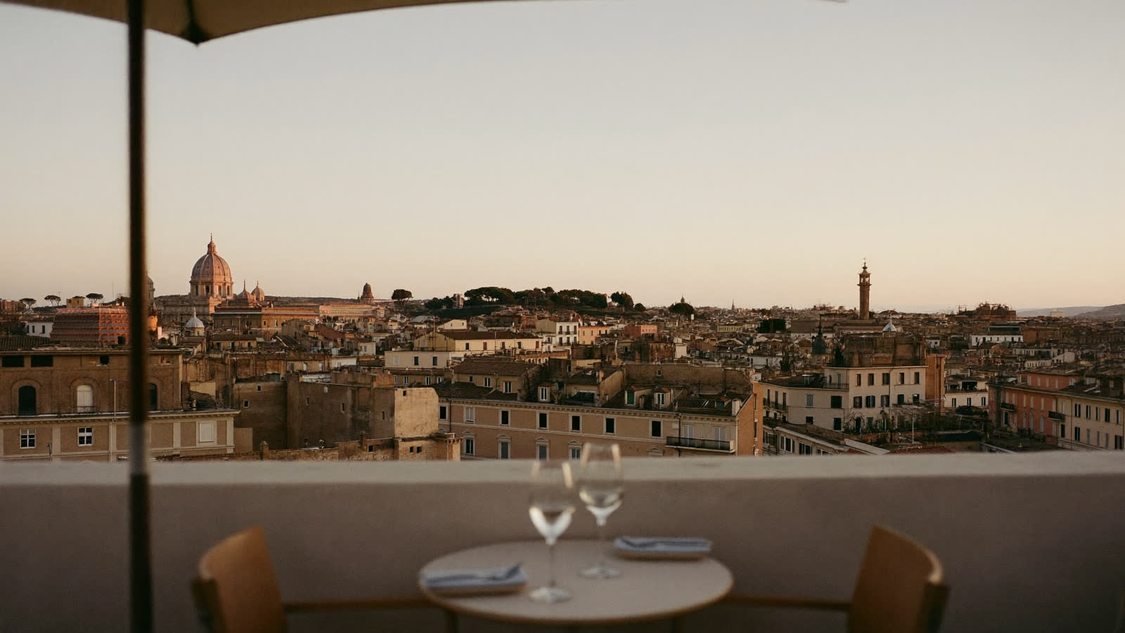 Rome rooftop terrace at golden hour with St Peter's dome on the horizon